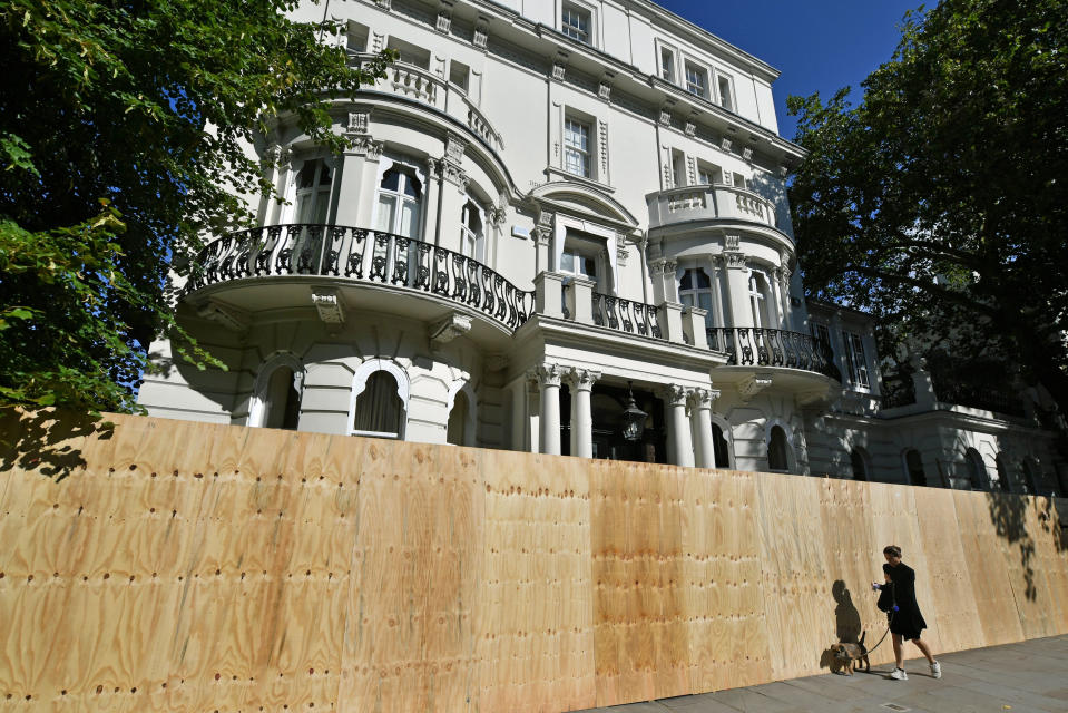 A woman walks past a boarded up property in Notting Hill, west London, ahead of Notting Hill Carnival (PA)