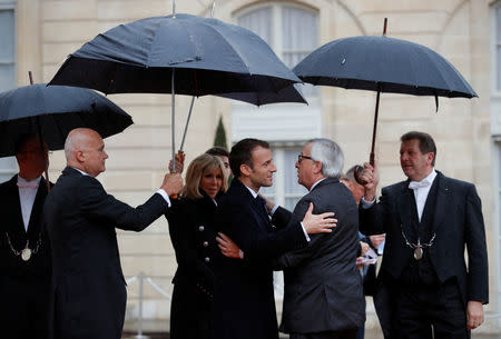 French President Emmanuel Macron and his wife Brigitte Macron welcome EU Commission President Jean-Claude Juncker at the Elysee Palace as part of the commemoration ceremony for Armistice Day, 100 years after the end of the First World War, in Paris, France, November 11, 2018. REUTERS/Philippe Wojazer