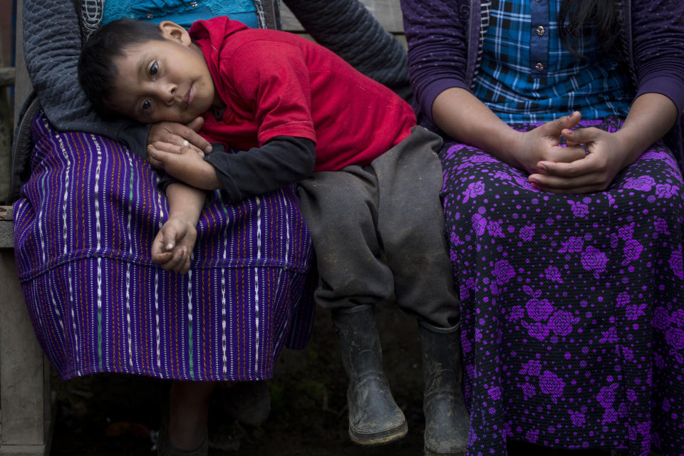 Six-year-old Mateo, the brother of Felipe Gomez Alonzo an 8-year-old Guatemalan boy who died in U.S. custody, rests his head on his mother's lap in their home in Yalambojoch, Guatemala, Saturday, Dec. 29, 2018. It was extreme poverty and lack of opportunity that drove Felipe’s father, Agustin Gomez, and mother Catarina Alonzo to decide that he and the boy would set off for the United States. (AP Photo/Moises Castillo)