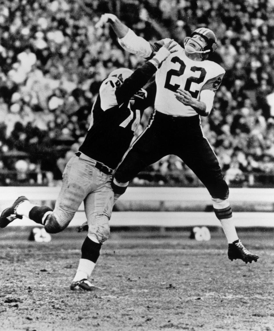 B.C. Lions quarterback Joe Kapp gets his pass away under pressure from Pete Neumann of the Hamilton Tiger-Cats during the third quarter of the 1964 Grey Cup game. (The Canadian Press)