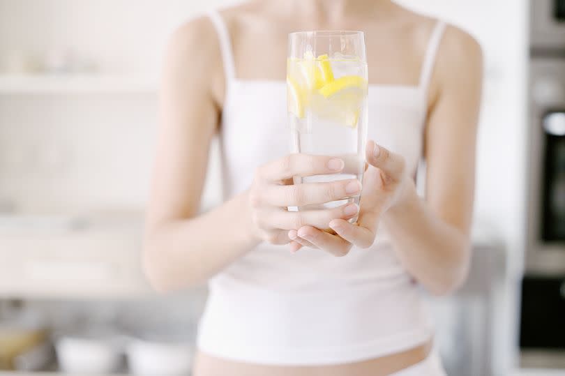 Woman holding lemon water