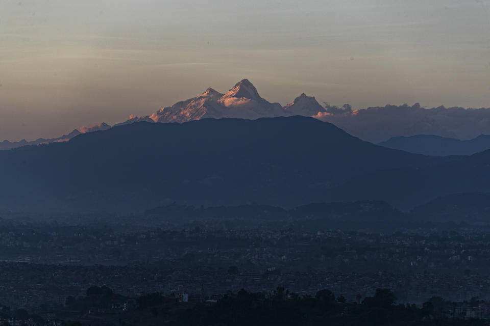 Himalchuli mountain, center and the Manasulu Mountain range, right is seen from Bhaktapur, Nepal Saturday, Oct 31, 2020. Nepal has reopened its peaks and trails for foreign adventurers in hopes of providing much needed income for hundreds of thousands of guides, porters and workers who have been unemployed for months because of the pandemic. (AP Photo/Niranjan Shrestha)