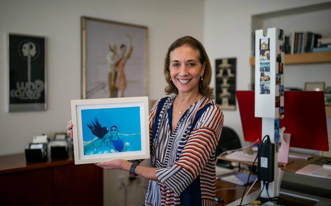 Lourdes López, the Cuban-American artistic director of Miami City Ballet and former principal dancer of New York City Ballet, holds a photograph of her two daughters, Adriel Saporta, far left, and Calliste Skouras, at her MCB office on Wednesday, June 29, 2022, in Miami Beach, Florida.