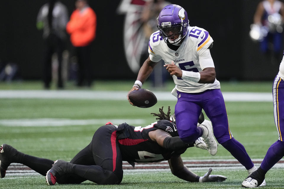 Minnesota Vikings quarterback Joshua Dobbs (15) runs for a first down past an Atlanta Falcons' defender during the second half of an NFL football game, Sunday, Nov. 5, 2023, in Atlanta. (AP Photo/John Bazemore)