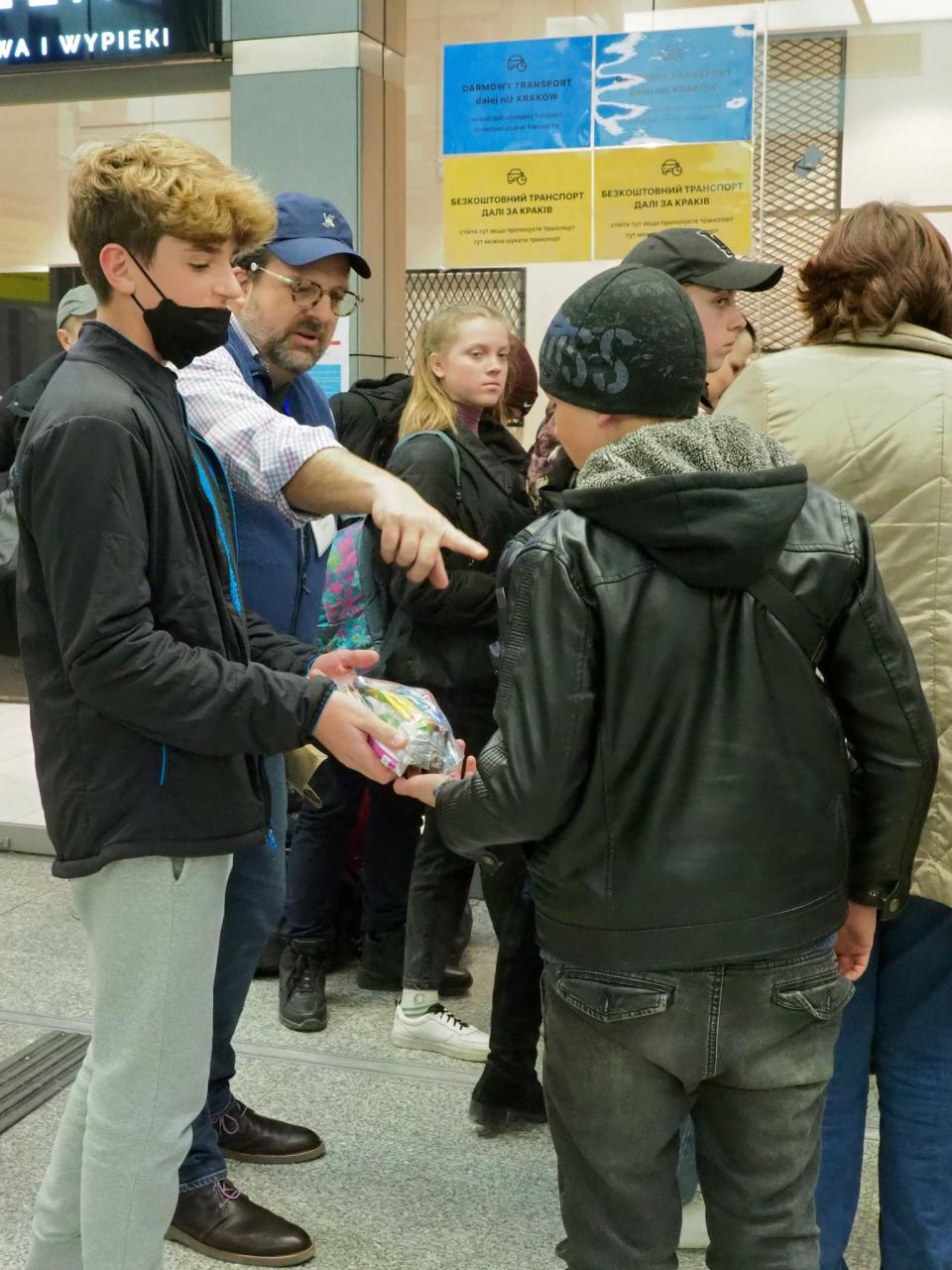 Rabbi David-Seth Kirshner giving out food to refugees at a train station in Krakow, Poland.