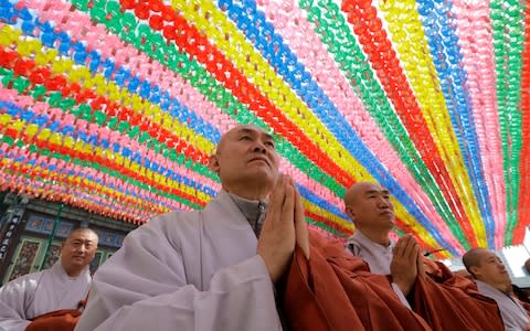 Buddhist monks put their hands together to wish for a successful inter-Korean summit at the Jogye temple in Seoul - Credit: Lee Jin-man/AP