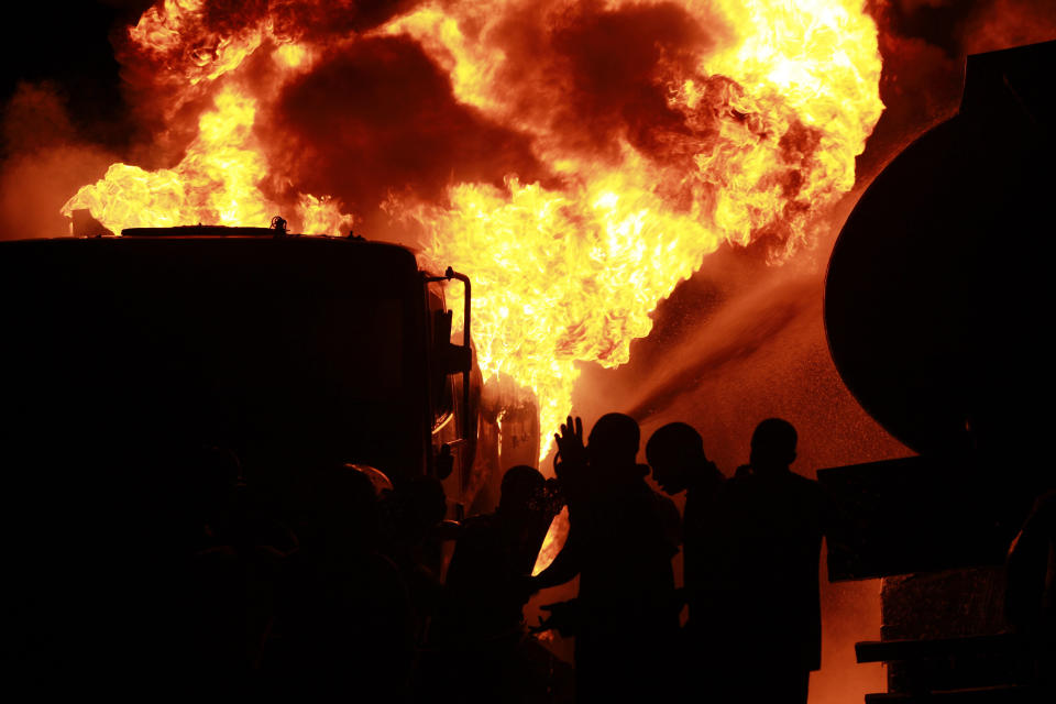 Firefighters try to contain a fire at an informal diesel fuel depot in Lagos, Nigeria on Thursday, Aug. 1, 2013. Witnesses said no one was injured in the fire that consumed a number of trucks at the site. Authorities continue to investigate what caused the blaze. (AP Photo/Sunday Alamba)