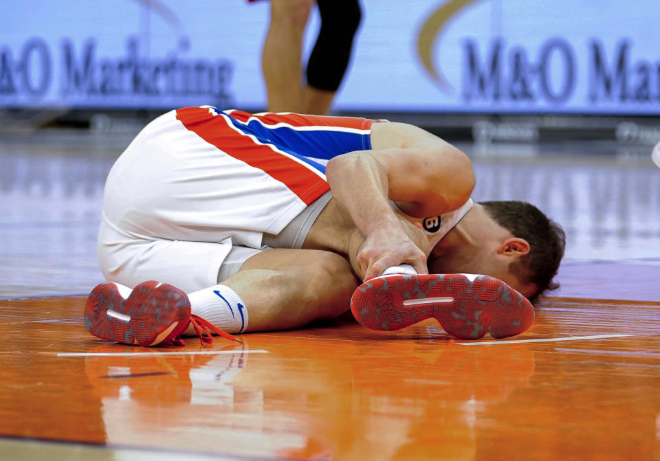 Detroit Pistons' Bojan Bogdanovic grabs his leg after falling to the court during the second half of the team's NBA basketball game against the Phoenix Suns in Phoenix, Friday, Nov. 25, 2022. (AP Photo/Darryl Webb)
