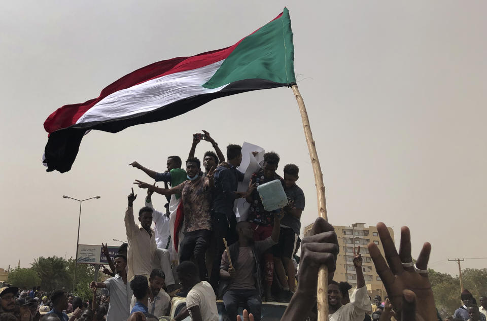 FILE - In this June 30, 2019, file photo, Sudanese protesters shout slogans as they march during a demonstration against the military council, in Khartoum, Sudan. An African Union envoy says Sudan's ruling military council and the country's pro-democracy movement have reached a power-sharing agreement, including a timetable for a transition to civilian rule. Mohammed el-Hassan Labat said early Friday, July 5, that both sides agreed to form a joint sovereign council that will rule the country for "three years or a little more." The sides agreed to five seats for the military and five for civilians with an additional seat going to a civilian with military background. (AP Photo/Hussein Malla, File)