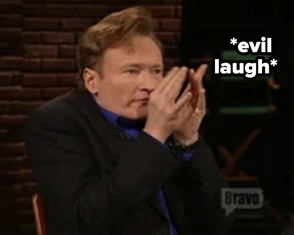 Conan O'Brien wearing a suit, enthusiastically clapping his hands on a television show set