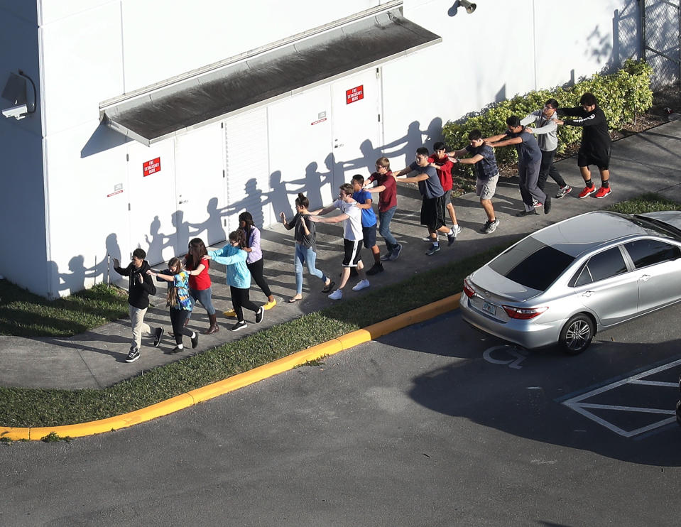 <p>People are brought out of the Marjory Stoneman Douglas High School after a shooting at the school that reportedly killed and injured multiple people on Feb. 14, 2018 in Parkland, Fla. (Photo: Joe Raedle/Getty Images) </p>