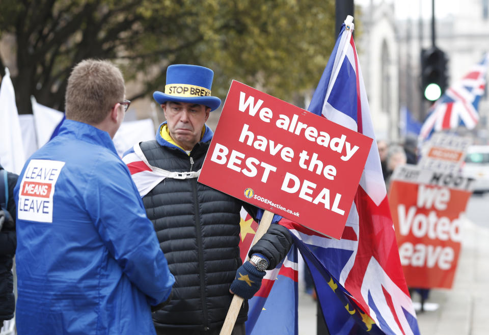 Pro-Brexit, left, and anti-Brexit, right, protesters debate their views outside parliament in London, Thursday Jan. 10, 2019. Prime Minister Theresa May's proposed Brexit deal seems widely disliked by both pro-European and pro-Brexit politicians, threatening the exit agreement and future relations with EU. (AP Photo/Alastair Grant)