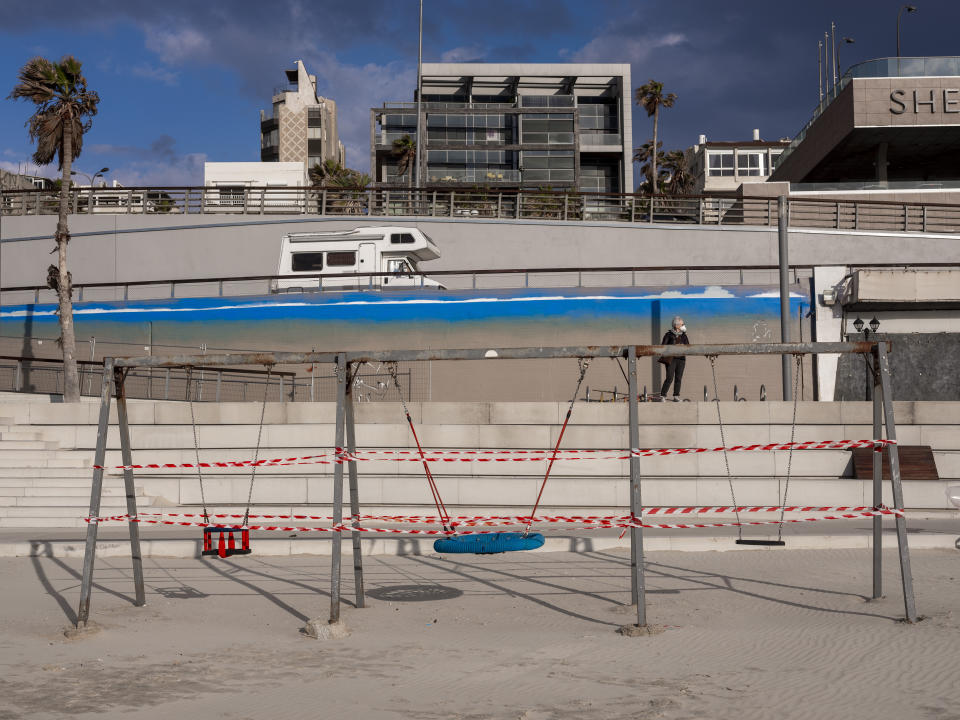 This Thursday, March 19, 2020 photo shows swings at Tel Aviv's beachfront wrapped in tape to prevent public access. Israel has reported a steady increase in confirmed cases despite imposing strict travel bans and quarantine measures more than two weeks ago. Authorities recently ordered the closure of all non-essential businesses and encouraged people to work from home. (AP Photo/Oded Balilty)