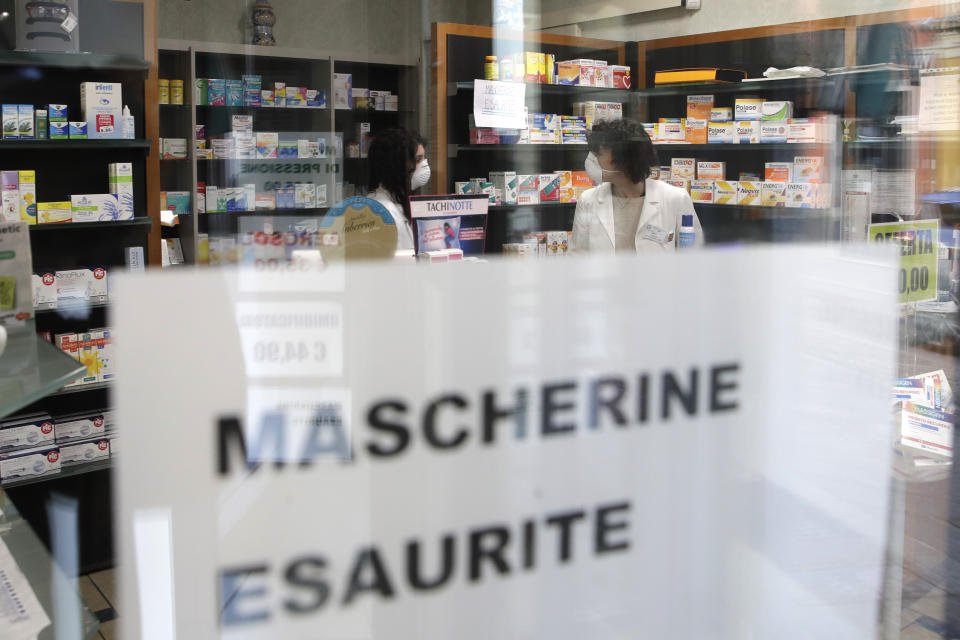 FILE - In this Saturday, Feb. 22, 2020 filer, a note reading in Italian "Masks sold out" hangs on the window of a pharmacy in Codogno, near Lodi, Northern Italy. Italy’s virus reopening phase was supposed to have been accompanied by a series of measures to limit infections in the onetime European epicenter of the pandemic: the distribution of millions of cheap surgical masks to pharmacies and tobacco shops nationwide, a pilot project of 150,000 antibody tests and, eventually, the roll-out of a contact-tracing app. (AP Photo/Luca Bruno, File)