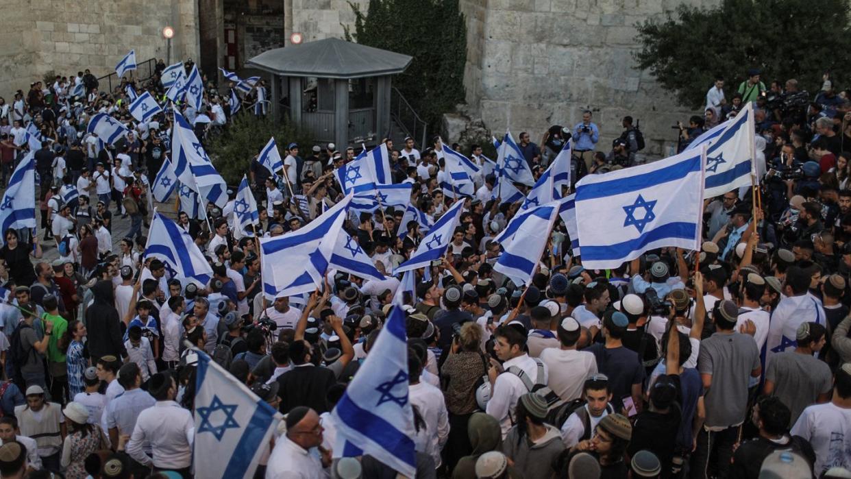 Menschen schwenken israelische Fahnen bei dem umstrittenen Flaggenmarsch in Jerusalem, der von rechtsgerichteten Nationalisten in Israel organisiert worden ist. Tausende Nationalisten zogen bei dem Marsch durch die Stadt.
