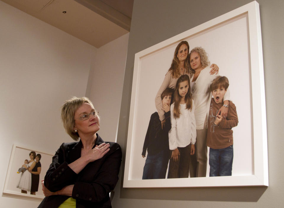 Photographer Carolyn Sherer looks at her group of photographs of lesbian families on Thursday, March 29, 2012 at the Civil Rights Institute in Birmingham, Ala.,Thursday, March 29, 2012. The photographs will be displayed thru June. Sherer says she hopes the photographs start a conversation about equality for everyone. (AP Photo/Dave Martin)