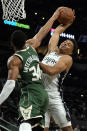 Milwaukee Bucks' Giannis Antetokounmpo (34) blocks a shot by San Antonio Spurs' Keldon Johnson during the first half of an NBA basketball in San Antonio, Texas, Saturday, Oct. 23, 2021. (AP Photo/Chuck Burton)