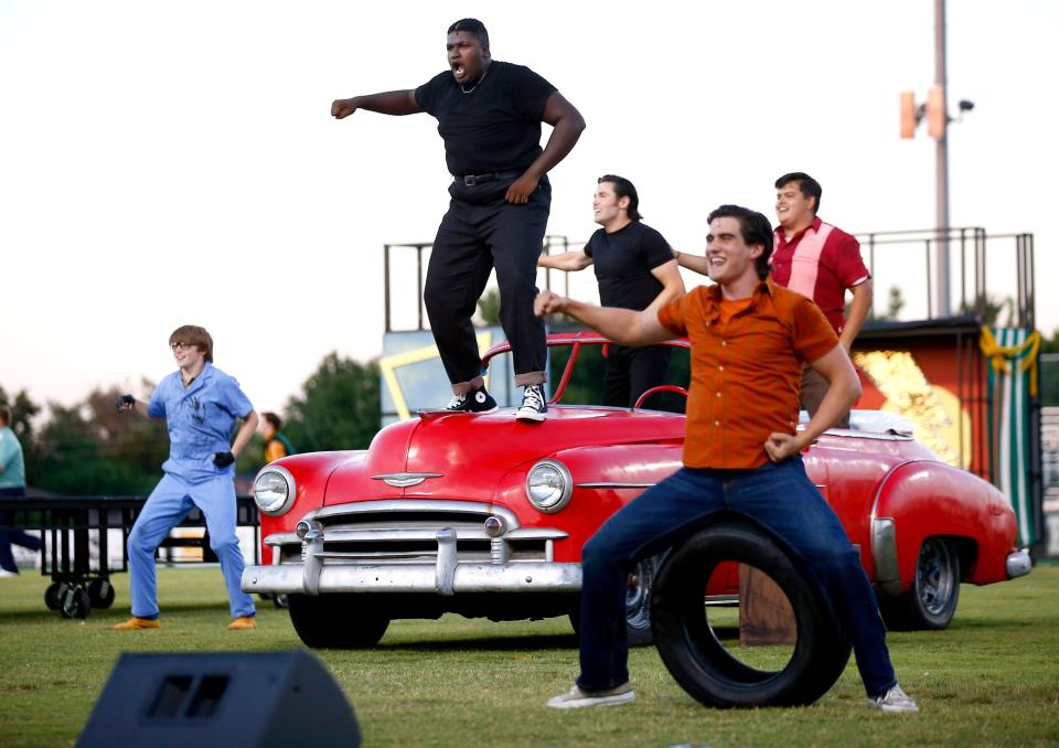 Caleb Barnett performs the role of Kenickie during the "Greased Lightnin'" number of Lyric Theatre's production of the musical "Grease" at Bishop McGuinness Catholic High School’s Pribil Football Stadium in Oklahoma City, Tuesday, June 15, 2021. After producing its entire 2021 season outdoors in response to the COVID-19 pandemic, Lyric Theatre's staff delayed from February to April plans to move back to indoor shows due to the surge in cases caused by the omicron variant.