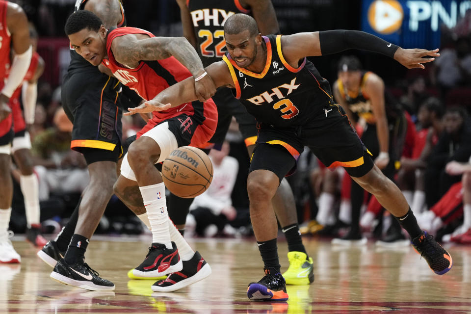 Houston Rockets guard Kevin Porter Jr., left, and Phoenix Suns guard Chris Paul chase the ball during the first half of an NBA basketball game, Tuesday, Dec. 13, 2022, in Houston. (AP Photo/Eric Christian Smith)