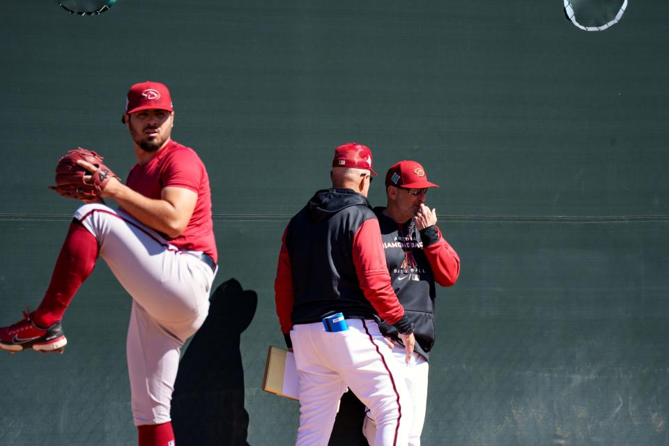 D-Backs manager, Torey Lovullo, right, talks with pitching coach, Brent Strom, while Humberto Castellanos, left, pitches at Salt River Fields at Talking Stick on March 11, 2022 in Scottsdale, Arizona.