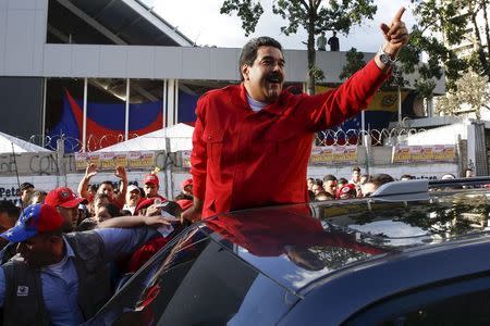 Venezuela's President Nicolas Maduro (C) greets supporters after a visit to inspect the progress of a Metrocable station and a meeting with supporters in the Petare slum district of Caracas December 1, 2015. REUTERS/Carlos Garcia Rawlins