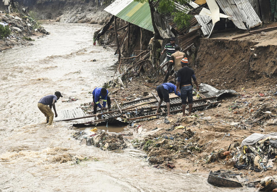 Men salvage parts from their destroyed home, following heavy rains caused by Cyclone Freddy in Blantyre, southern Malawi, Wednesday, March 15, 2023. After barreling through Mozambique and Malawi since late last week and killing hundreds and displacing thousands more, the cyclone is set to move away from land bringing some relief to regions who have been ravaged by torrential rain and powerful winds. (AP Photo/Thoko Chikondi)