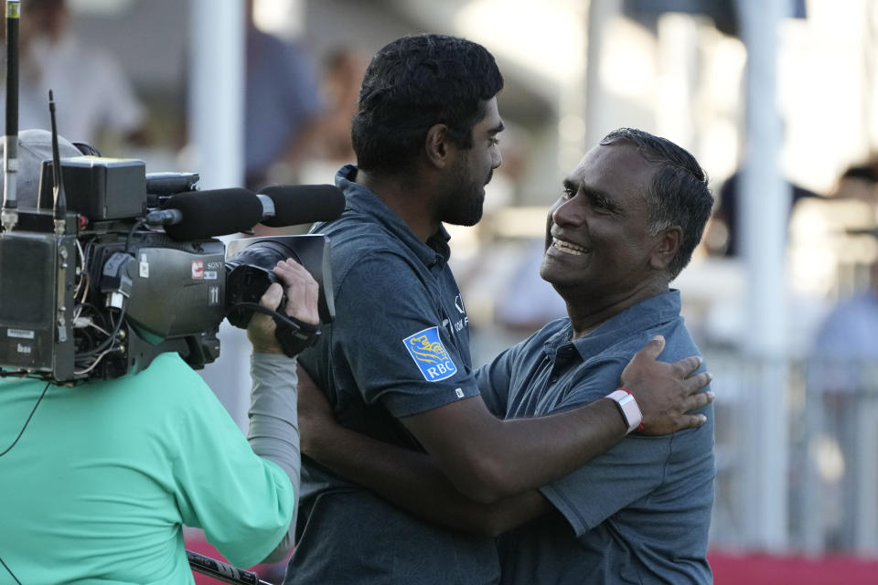 Sahith Theegala, center, is greeted by his father Muralidhar Theegala, right, on the 18th green of the Silverado Resort North Course after winning the Fortinet Championship PGA golf tournament in Napa, Calif., Sunday, Sept. 17, 2023. (AP Photo/Eric Risberg)