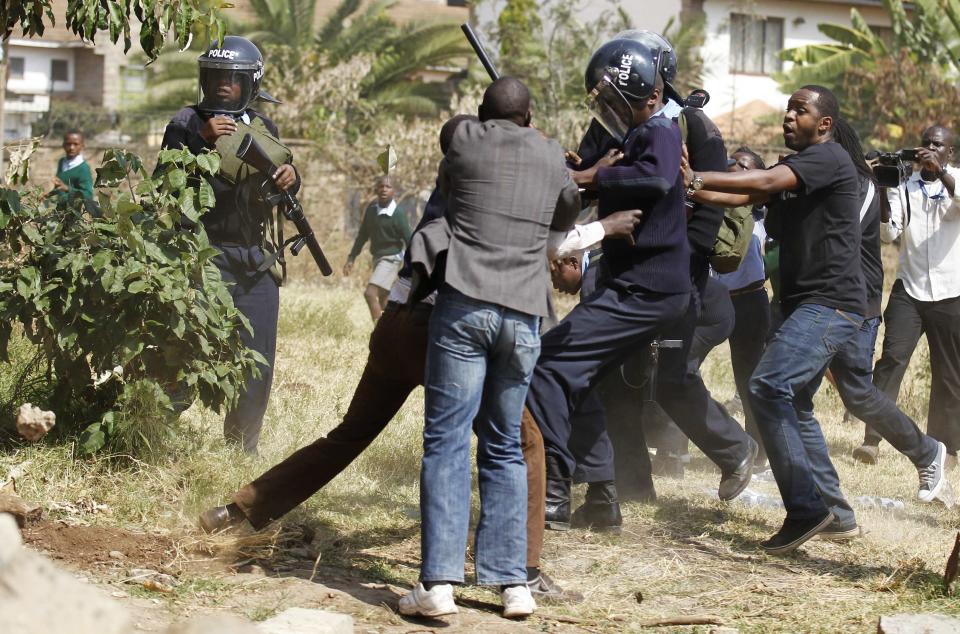 Riot police scuffle with members of the civil society after they demolished a perimeter wall erected by a private developer around Langata primary school playground in Nairobi