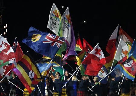 Performers wave flags during the closing ceremony of the 2014 Commonwealth Games at Hampden Park in Glasgow, Scotland August 3, 2014. REUTERS/Phil Noble