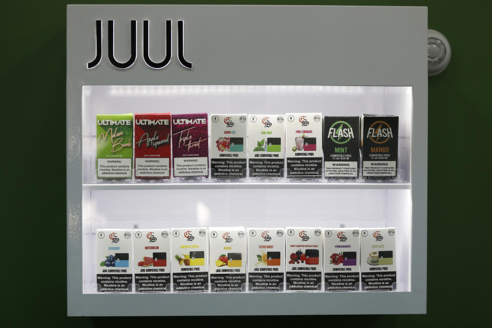 FILE - In this Sept. 3, 2019, file photo, electronic cigarette pods are displayed for sale at a shop, in Biddeford, Maine. Vaping giant Juul Labs has donated thousands of dollars to court state attorneys general. But the lobbying strategy may be backfiring. (AP Photo/Robert F. Bukaty, File)