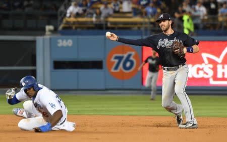 Jun 9, 2018; Los Angeles, CA, USA; Atlanta Braves shortstop Dansby Swanson (right) turns a double play over Los Angeles Dodgers right fielder Yasiel Puig (66) in the 9th inning at Dodger Stadium. Mandatory Credit: Richard Mackson-USA TODAY Sports