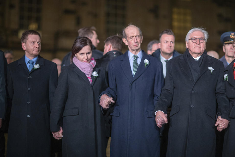 German Federal President Frank-Walter Steinmeier, centre, stands with various dignitaries and guest including Britain's Duke of Kent, 2nd right, and Michael Kretschmer Prime Minister of Saxony, left, and his partner Annett Hofmann, as they join a human chain, marking the 75th anniversary of the destruction of Dresden in the Second World War, in Dresden, Germany, Thursday Feb. 13, 2020. A 1945 allied bombing campaign reduced the centre of Dresden to rubble leaving about 25,000 people dead. (Jens B'ttner/dpa via AP)