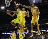 Michigan's Caris LeVert (23) shoots past Tennessee's Jarnell Stokes (5) and Jordan McRae (52) during the first half of an NCAA Midwest Regional semifinal college basketball tournament game Friday, March 28, 2014, in Indianapolis. (AP Photo/David J. Phillip)