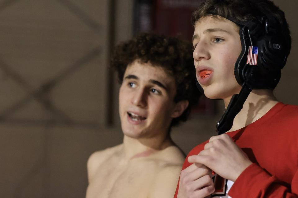 Brothers Zak Robinson (left) and Nate Robinson discuss strategy before the wrestling match against Bellingham at Holliston High School on Jan. 10, 2024.