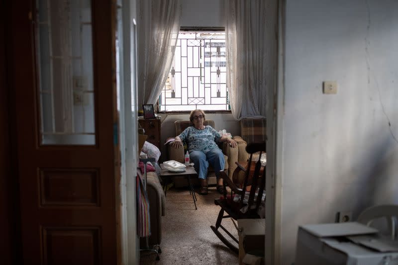 Marguerite Dirany, de 81 años, posa sentada en la sala de su casa que resultó dañada por una explosión en el puerto de Beirut, en el barrio de Karantina, Beirut, Líbano