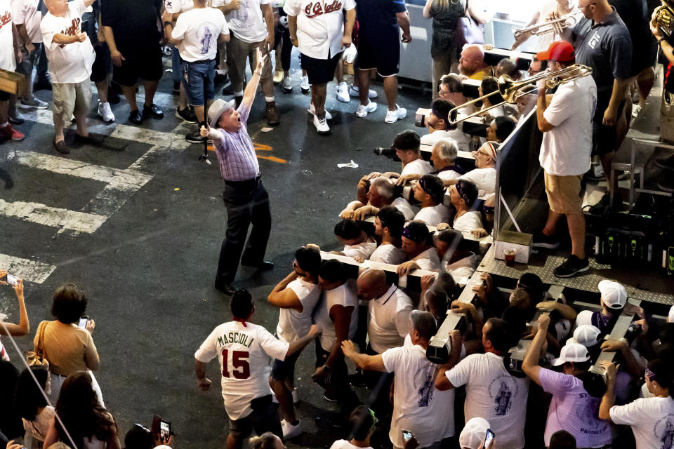 Lifters carry the 80-foot tall, 4-ton Giglio tower down Williamsburg's Havemeyer Street during the Giglio feast to recreate the return of St. Paulinus, the Bishop of Nola, Italy, Wednesday, July 13, 2012, in the Brooklyn borough of New York. (AP Photo/Julia Nikhinson)