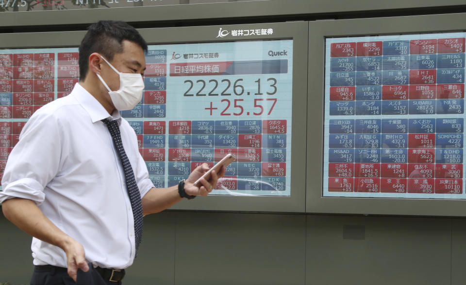 A man walks by an electronic stock board of a securities firm in Tokyo, Monday, April 22, 2019. Asian stock markets were mixed Monday following the Easter holiday weekend as investors looked ahead to U.S. and Japanese economic data. (AP Photo/Koji Sasahara)