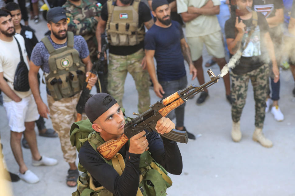 A member of the Palestinian Fatah Movement fires in the air during the funeral procession of Abu Ashraf al-Armoushi, the Palestinian National Security Commander in the Saida region, at Rashidiyeh Palestinian refugee camp, southern Lebanon, Monday, July 31, 2023. (AP Photo/Mohammad Zaatari)