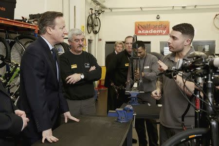 Britain's Prime Minister David Cameron talks to inmate Chris (R) inside the Halfords academy at HMP Onley, where inmates are being trained to become Halford's shop assistants and bicycle technicians in Rugby, central England, February 8, 2016. REUTERS/Christopher Furlong/Pool