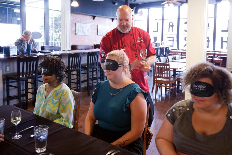 Kamp's 1910 Cafe chef Steve Stavinoha serves wine to The Oklahoman's Clytie Bunyan, left, Cheyenne Derksen and JaNae Williams during a blind tasting meal at Kamp's 1910 Cafe in Oklahoma City. NewView and Kamp's Cafe will host a Blackout Banquet on June 24 as a fundraiser and to raise awareness of the challenges facing the blind and low vision community.