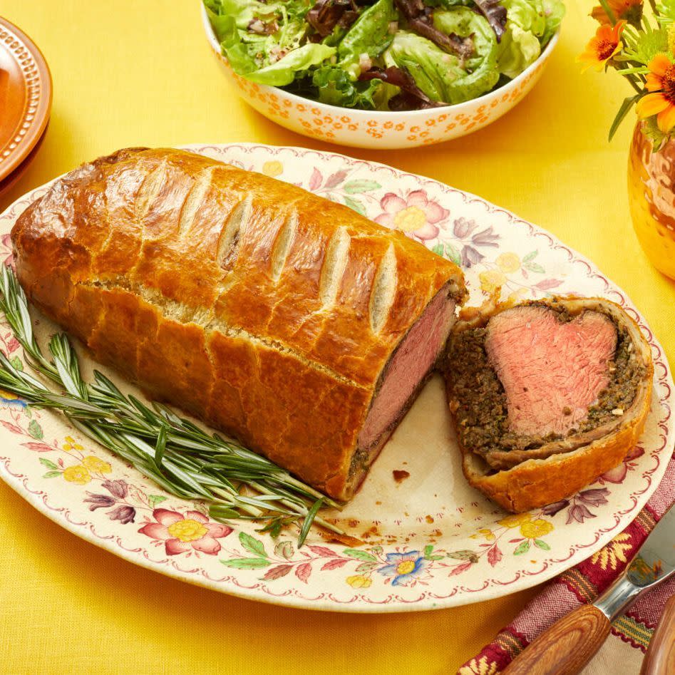 easter dinner ideas beef wellington on platter with rosemary and salad in back