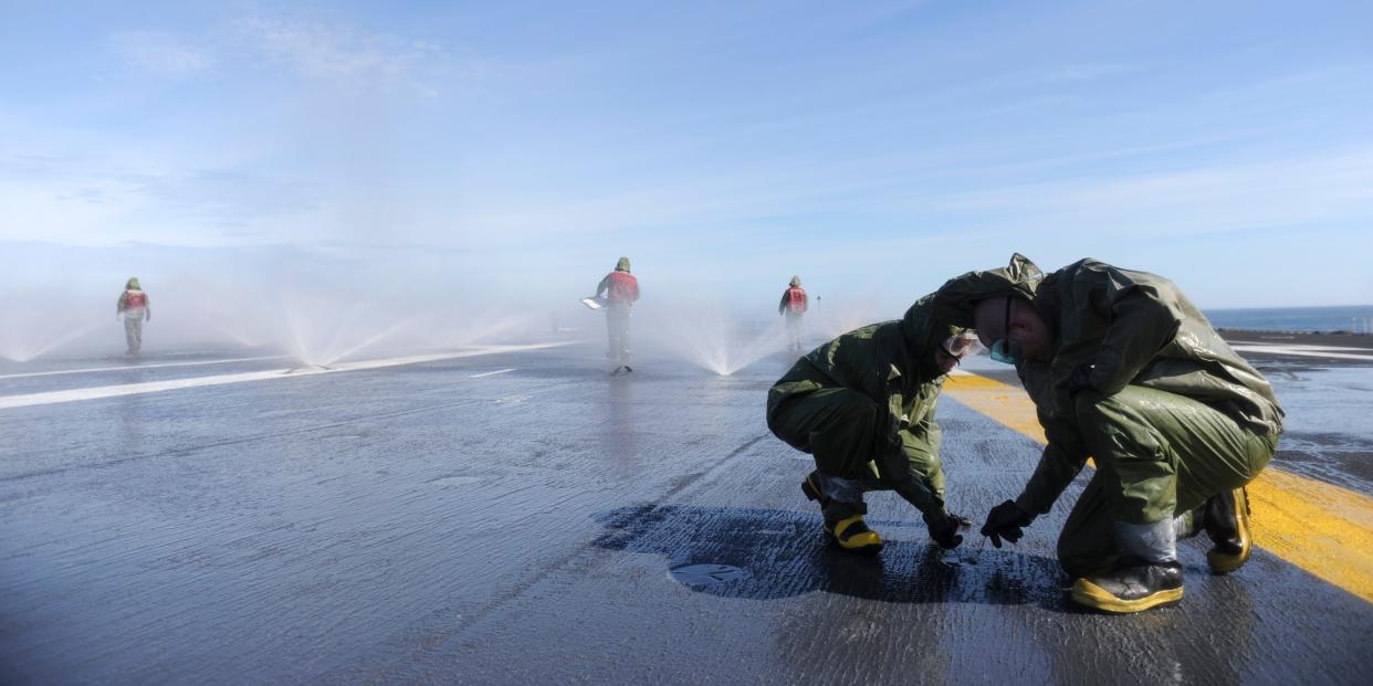 U.S. Sailors perform maintenance on sprinklers during a countermeasure wash down on the flight deck of the aircraft carrier USS Nimitz (CVN 68) in the Pacific Ocean April 29, 2014.