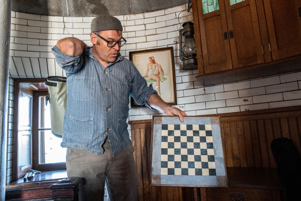 Dave Waller shows a checkers board made by a former lighthouse keeper at the Graves Light Station, Thursday, June 23, 2022.