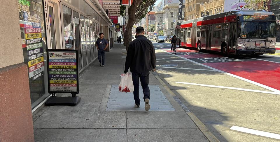 Andy Fang, DoorDash’s co-founder and chief technology officer, picks up and delivers food orders to customers in downtown San Francisco on Saturday, June 15, 2023. Fang is one of a growing number of executives who work shifts on the front lines of the companies they run. All DoorDash salaried employees are required to make deliveries or work directly with customers or merchants several times a year. (AP Photo/Terry Chea)