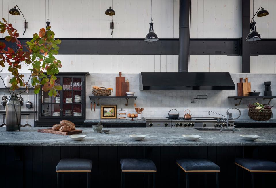 The barn’s massive open kitchen, which is the heart and soul of the space, has a 20-foot soapstone island with six hide-covered barstools from David Gaynor Design. The professional range is from BlueStar.
