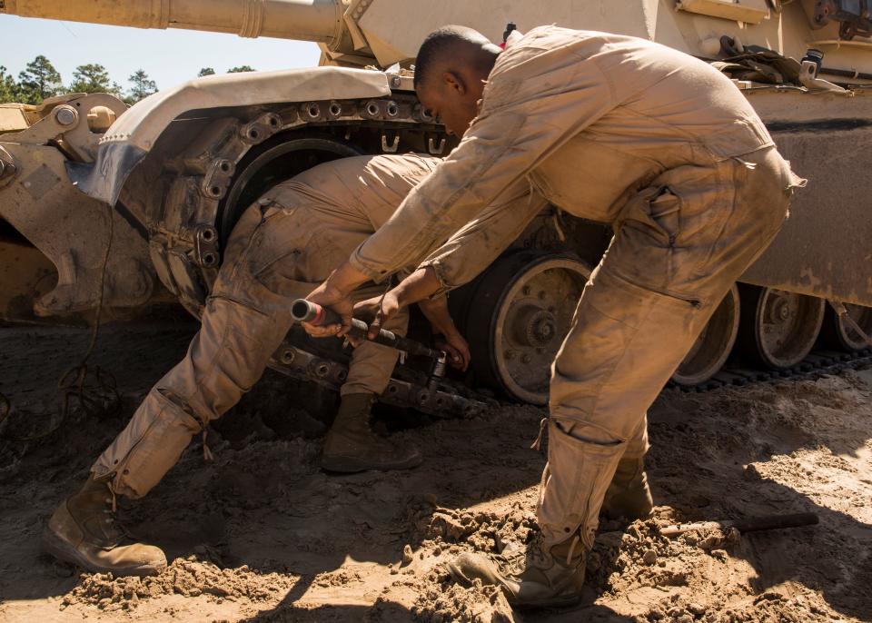 US Marines with Alpha Company, 2nd Tank Battalion prep the track on an M1A1 Abrams main battle tank in order to remove the front road wheel aboard Camp Lejeune, N.C., March 29, 2016.