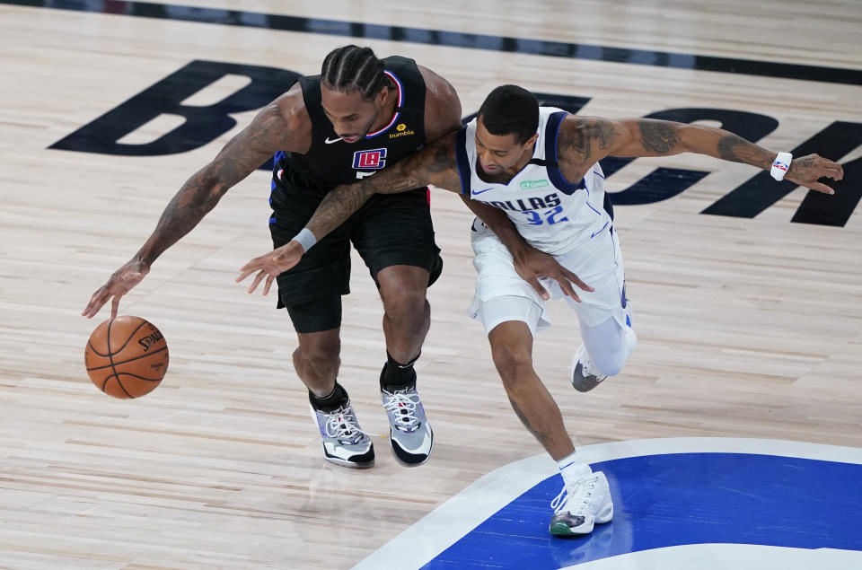 Los Angeles Clippers' Kawhi Leonard (2) goes around Dallas Mavericks' Trey Burke during the first half of an NBA first round playoff game Sunday, Aug. 30, 2020, in Lake Buena Vista, Fla. (AP Photo/Ashley Landis)