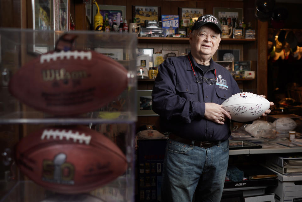 Don Crisman poses for a photo in his Kennebunk, Maine, home on Monday, Jan. 28, 2019, holding a Super Bowl LI ball signed by a few Patriots NFL football players. Crisman has never missed a Super Bowl and will be heading to Atlanta to watch his 53rd Super Bowl as the Patriots take on the Chiefs. (Gregory Rec/Portland Press Herald via AP)