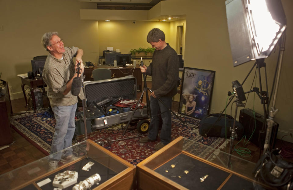 In this photo taken Jan. 5, 2012, a film crew from the television show "America's Most Wanted" sets up lighting and sound before recording a segment for the show about the Nov. 1, 2011 robbery at Stuart Kingston Jewelers in Wimington, Del. The U.S. Attorney's Office says four men have been arrested in connection with the theft of a $2 million ruby during a jewelry store heist in Wilmington, Del. Spokeswoman Kimberlynn Reeves said an indictment that had been returned in December against the suspects was unsealed Thursday, Feb. 20, 2014 after their arrest. The four are accused of robbing Stuart Kingston Jewelers in November 2011 and escaping with $4.4 million in jewelry, including the 5-inch, 4-pound Liberty Bell Ruby, made from the largest mined ruby in the world. The indictment says the armed, masked men restrained store employees with zip ties and duct tape and smashed glass display cases with hammers. Reeves said none of the jewelry has been recovered. (AP Photo/The News Journal, Jennifer Corbet)