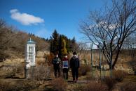 The Wider Image: Japan's tsunami survivors call lost loves on the phone of the wind